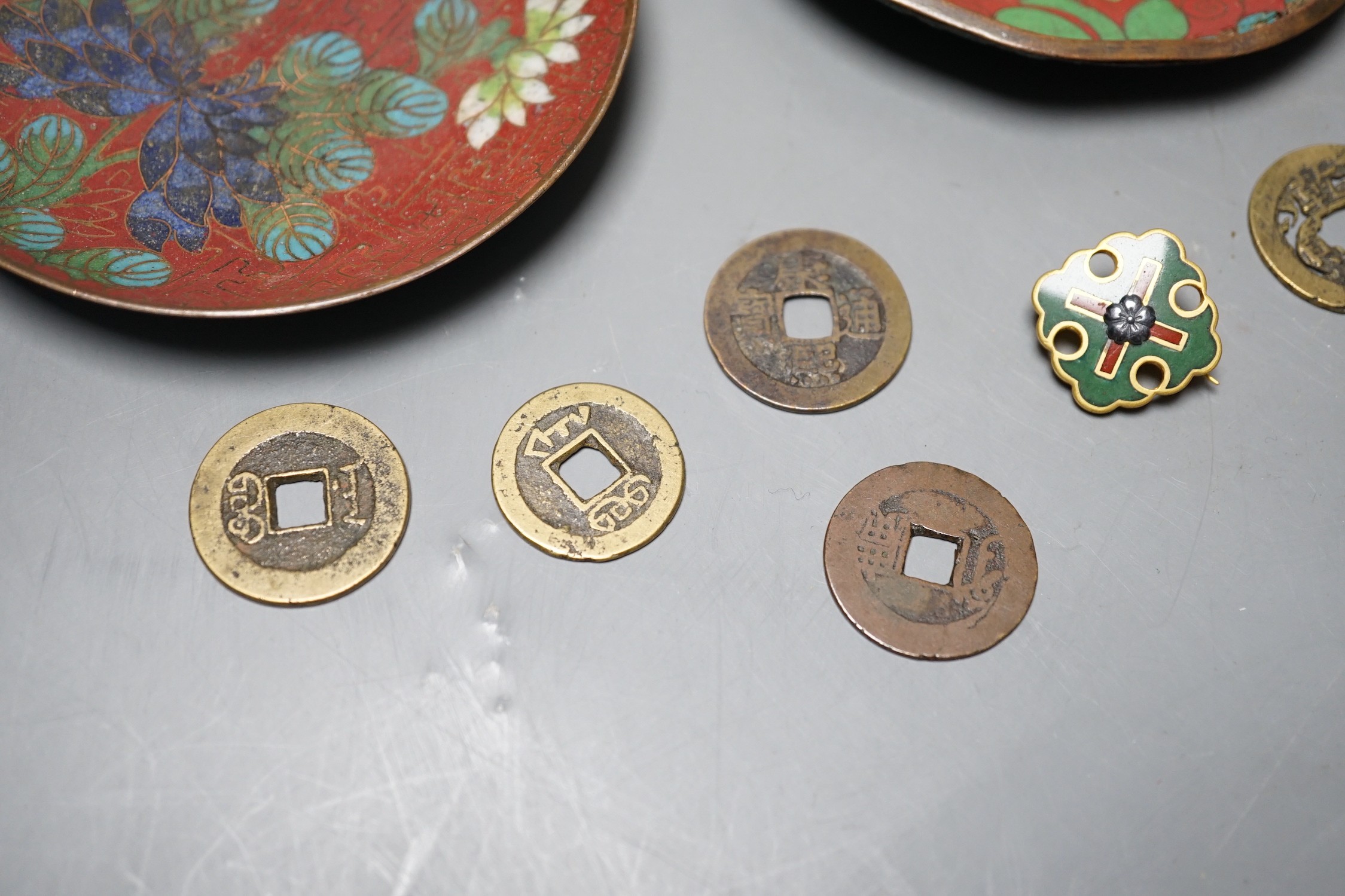 A group of Chinese coins, cloisonné enamel wares and an enamelled badge